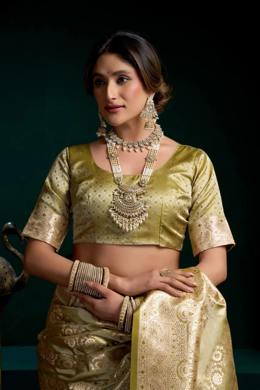 Woman wearing a traditional gold saree with jewelry against a dark background