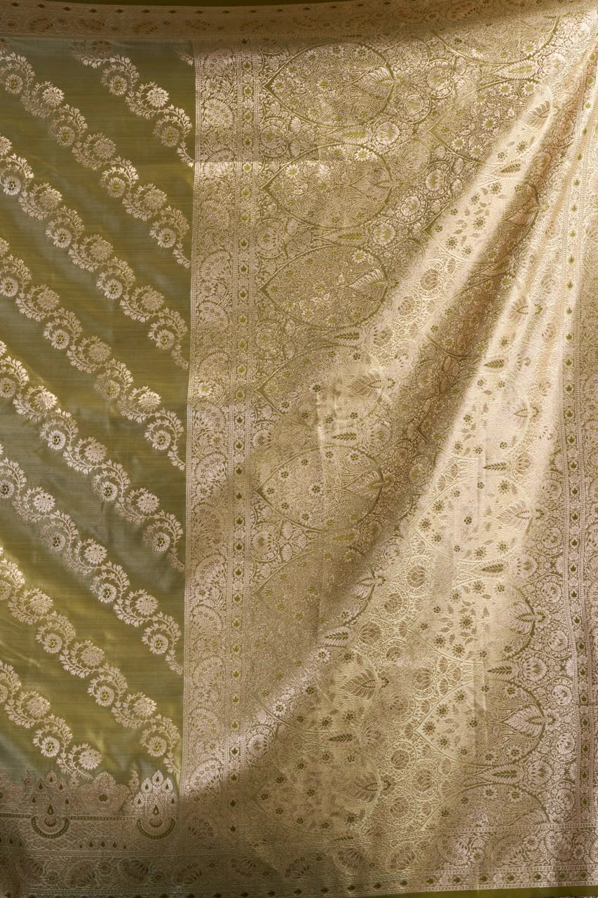 Patterned fabric with intricate designs in shades of green and beige.