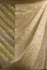 Patterned fabric with intricate designs in shades of green and beige.