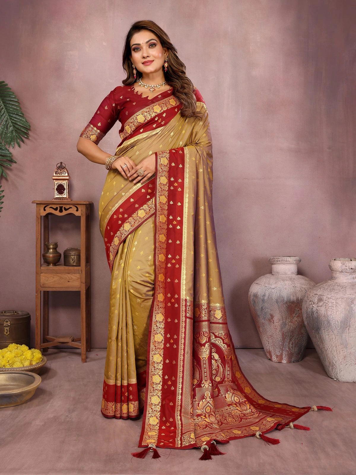 Woman wearing a red and gold saree with a neutral background