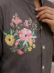 Detailed close-up of botanical floral print on gray cotton kurti featuring pink peonies, yellow daisies, green leaves, and contrast white stitching