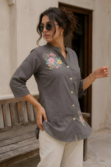Gray cotton kurti with floral print, side view showing button-down placket and side slit detail, model leaning against wooden bench