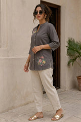 Gray floral print short kurti side 3/4 view showing A-line silhouette, 3/4 sleeves, and collar neckline, styled with white trousers