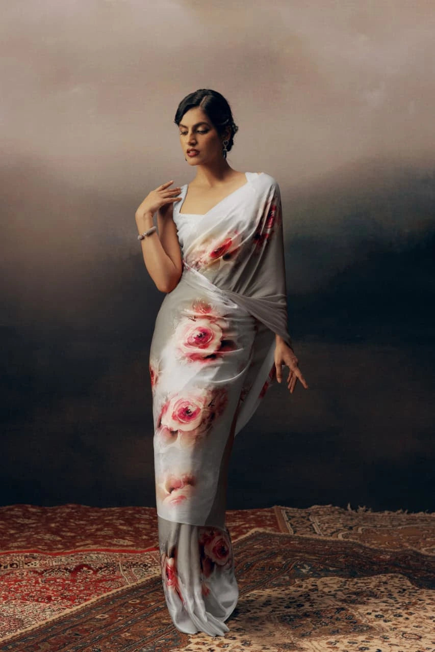 Woman wearing a floral saree against a dark background