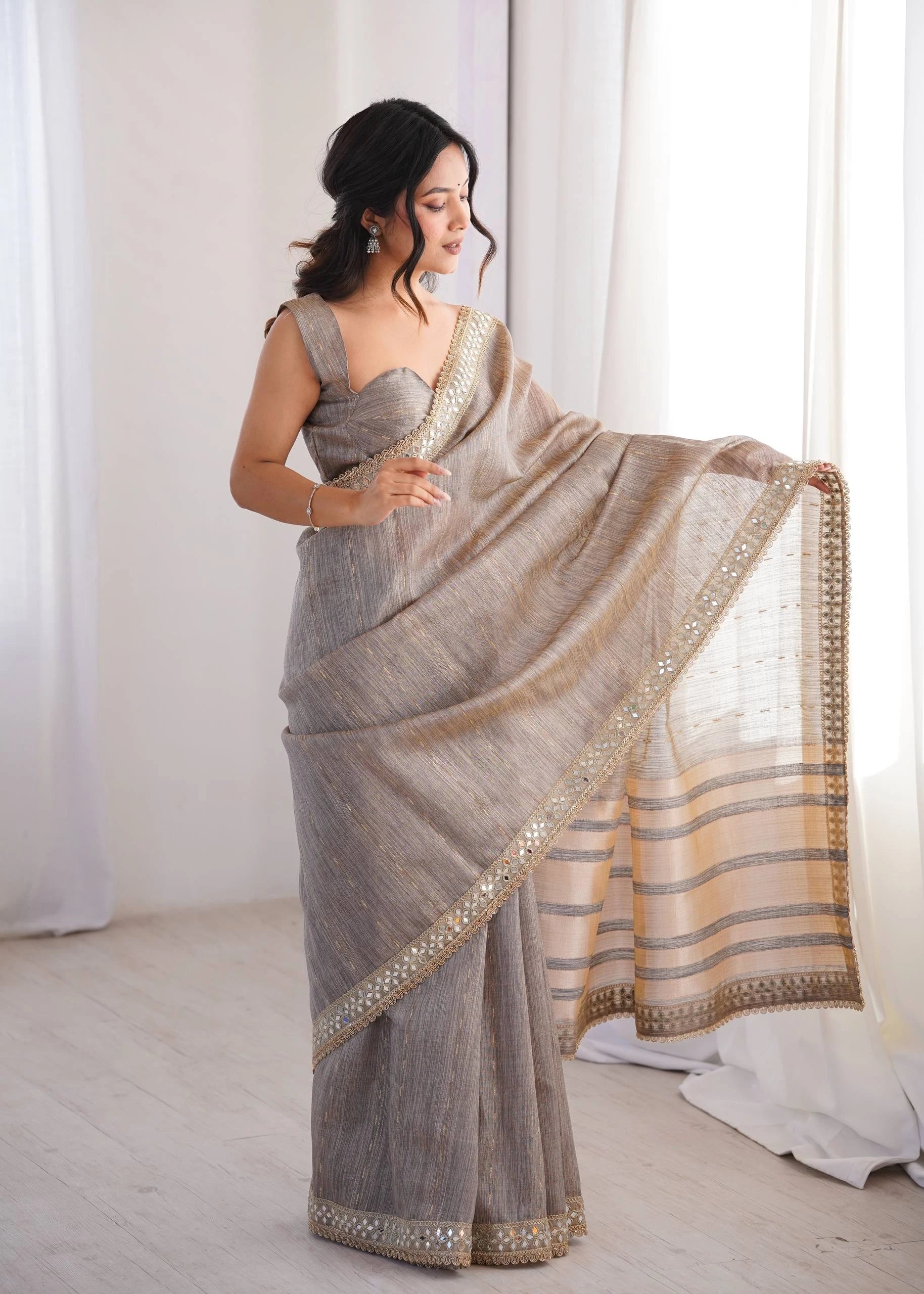 Woman wearing a saree with a plain background
