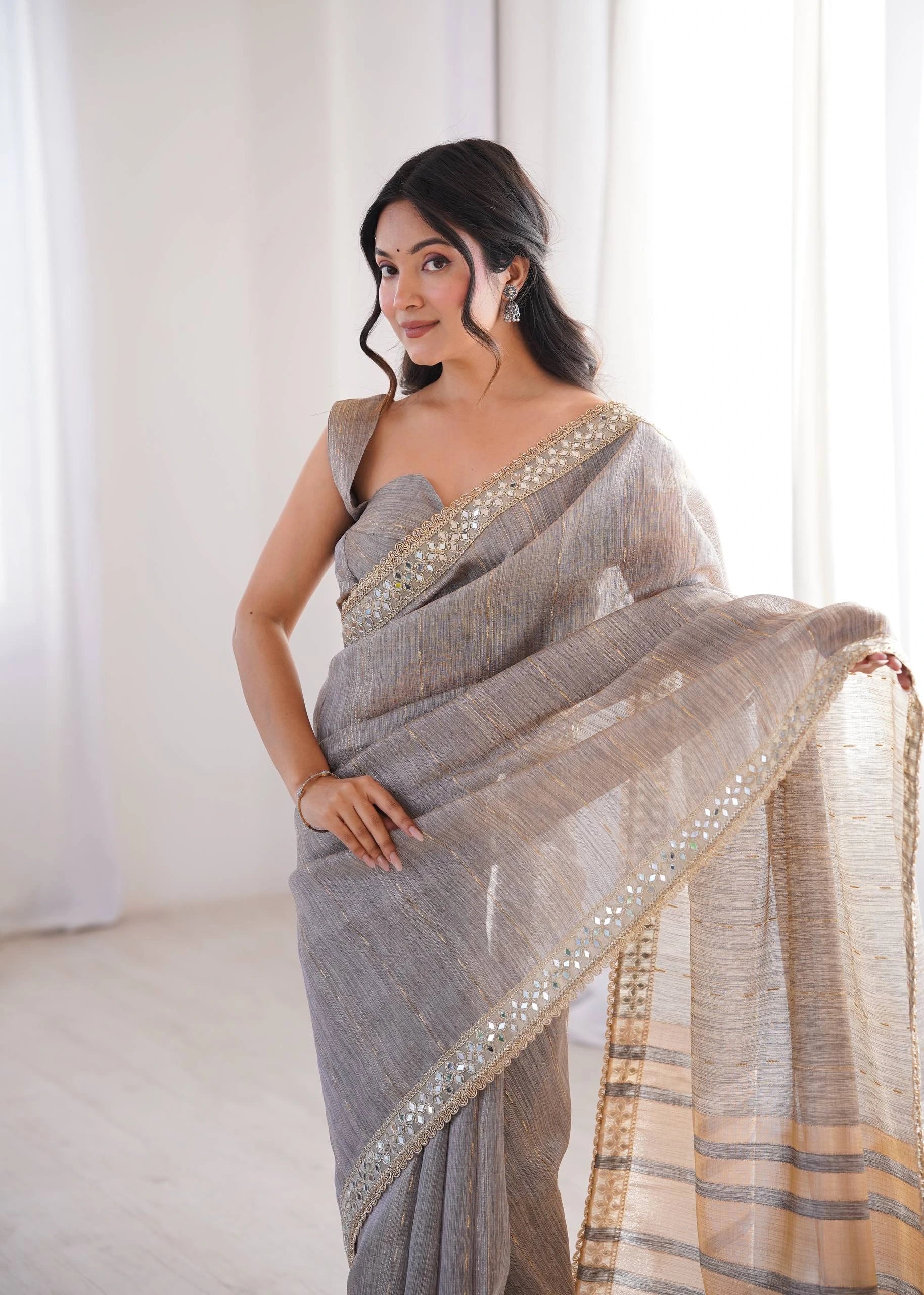 Woman wearing a gray saree with a white background
