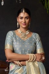 Woman in traditional attire with jewelry against a dark background