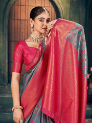 Woman in a red and green saree with jewelry, standing indoors.