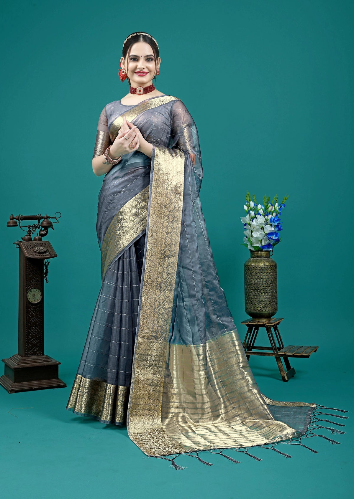 Elegant grey saree with intricate golden zari woven border detailing.
