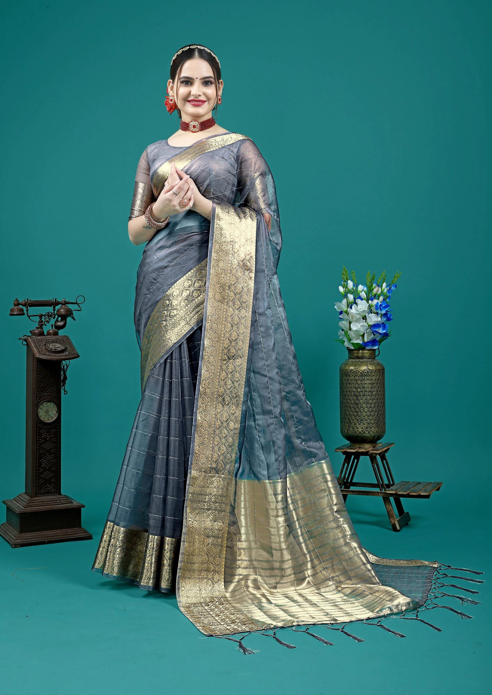 Elegant grey saree with intricate golden zari woven border detailing.