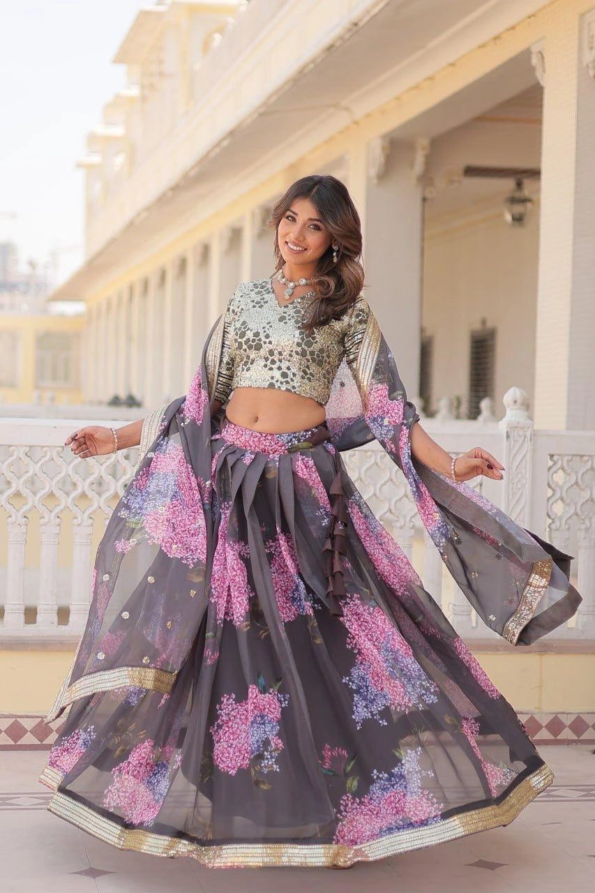 Woman in a floral traditional outfit standing in front of a building.