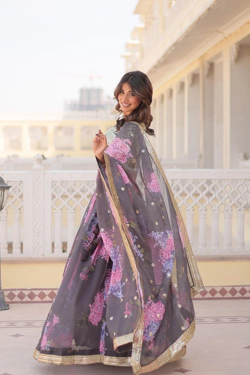 Woman wearing a floral saree in front of a white building with columns