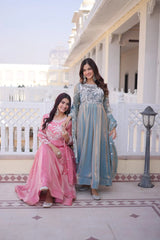 Two women in traditional outfits standing in front of a white building with columns.