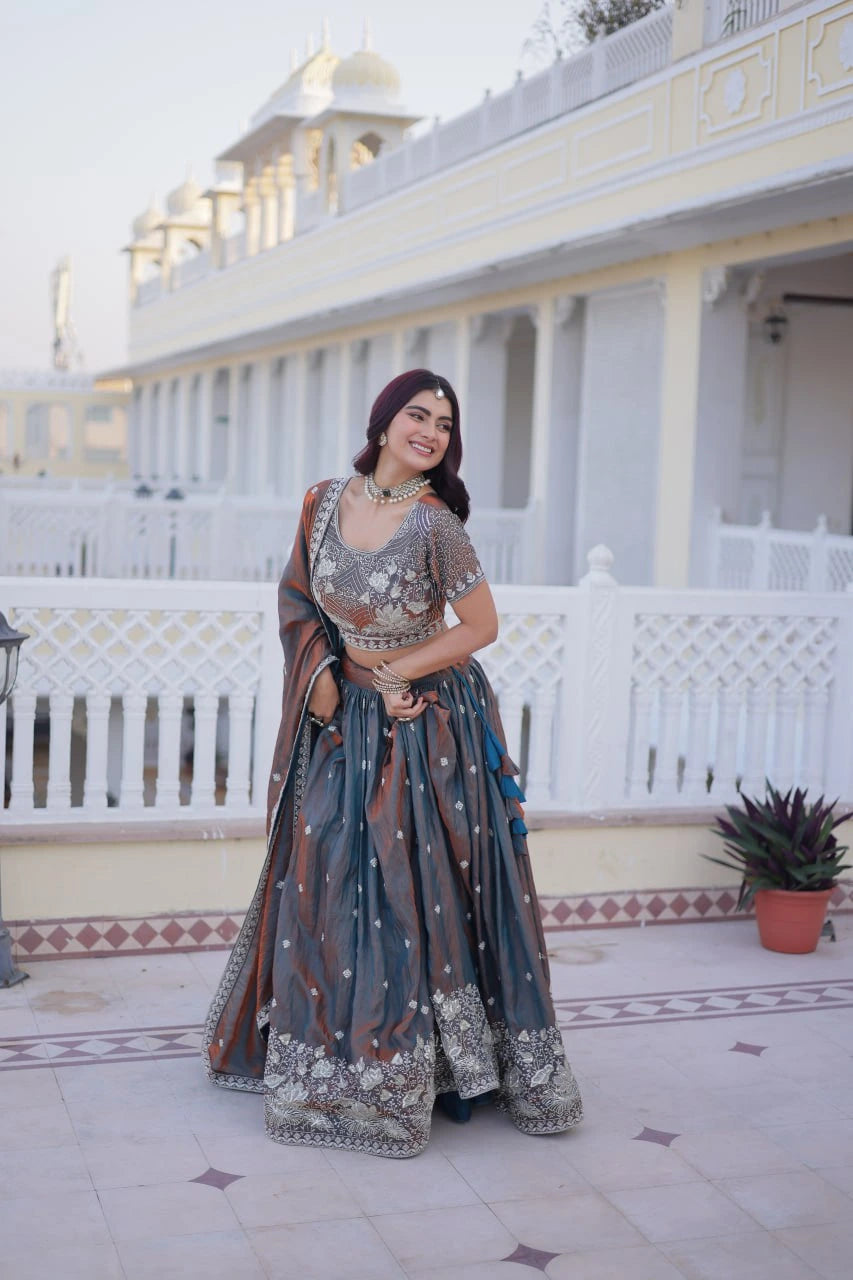 Woman in traditional outfit standing in front of a white building with a dome.