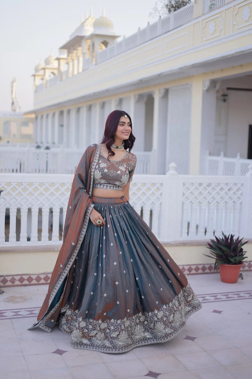Woman in traditional outfit standing in front of a white building with architectural details.
