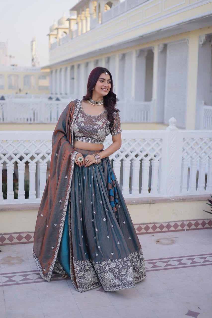 Woman in traditional outfit standing on a balcony with white railing and building in the background