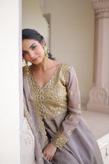 Woman in a traditional embroidered outfit with gold detailing