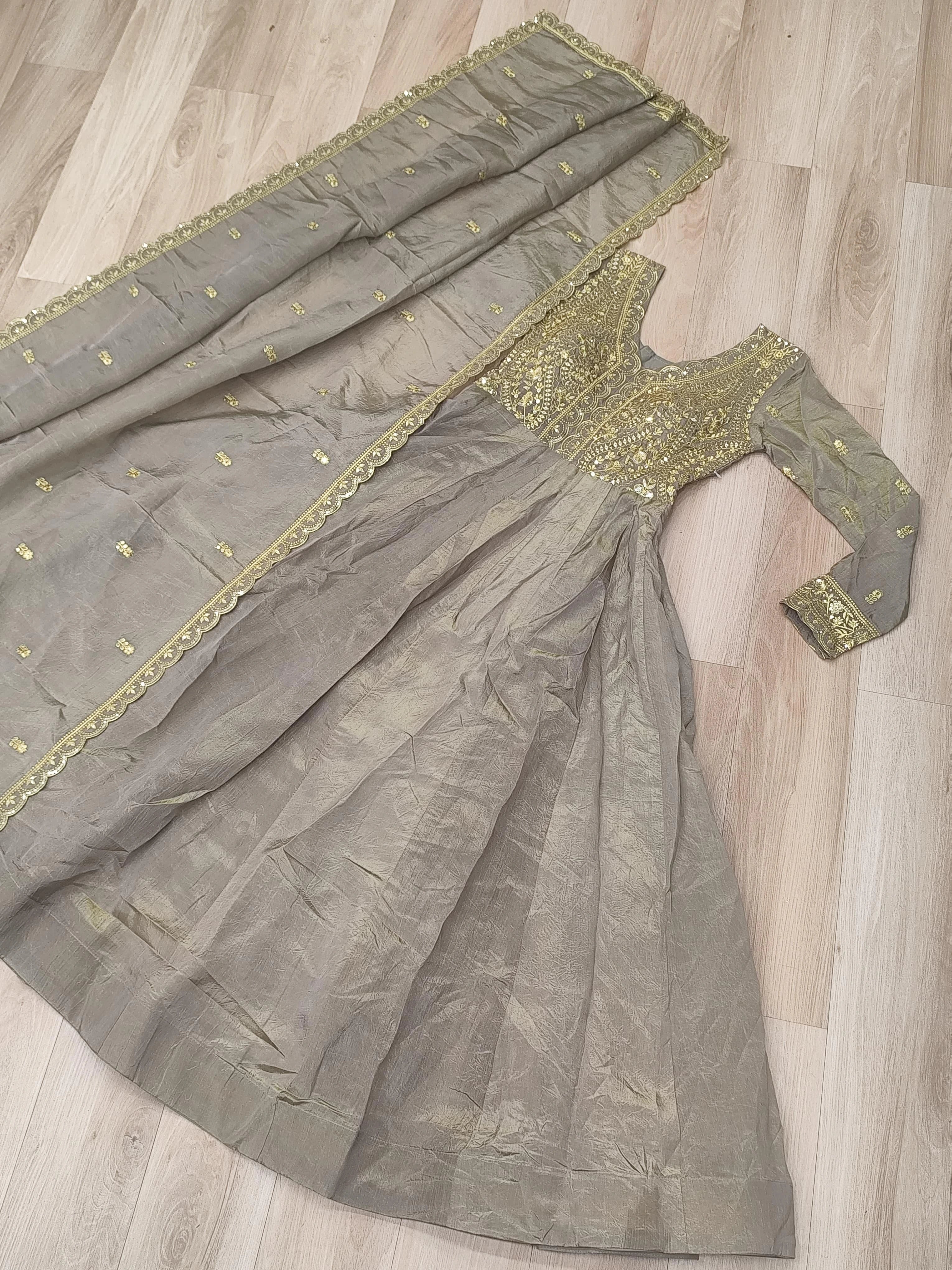 Gray saree with gold embroidery on a wooden floor
