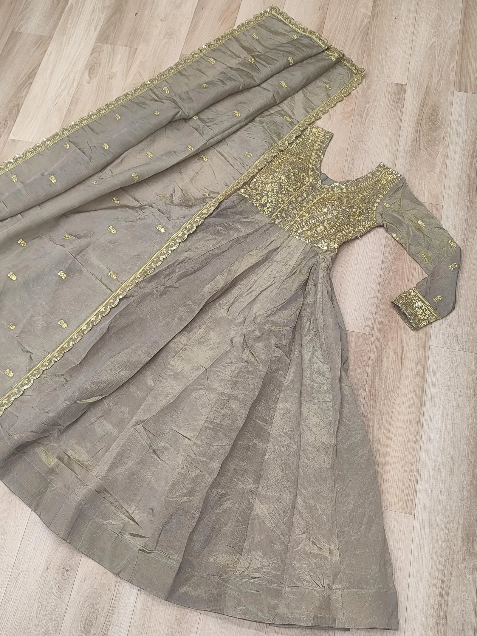 Gray saree with gold embroidery on a wooden floor