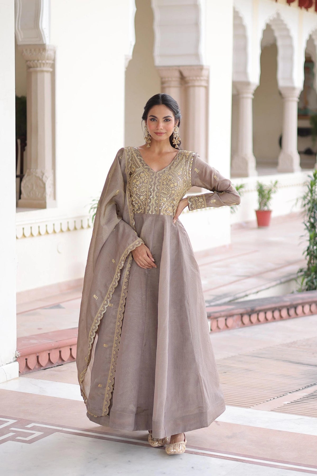Woman in a traditional outfit standing in an architectural setting