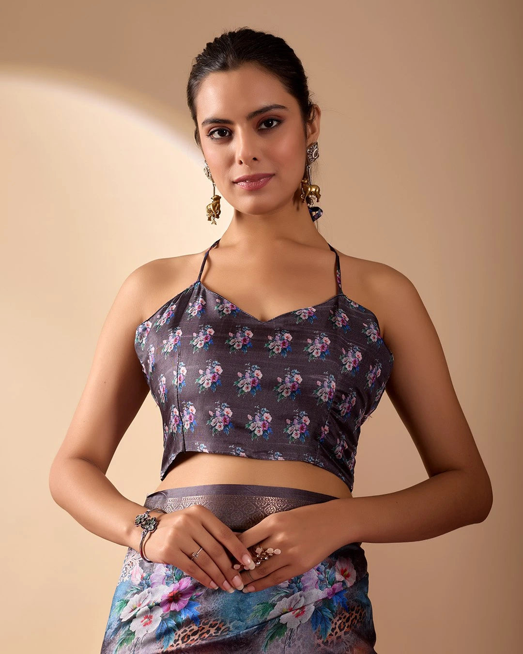 Woman wearing a floral top and skirt against a beige background