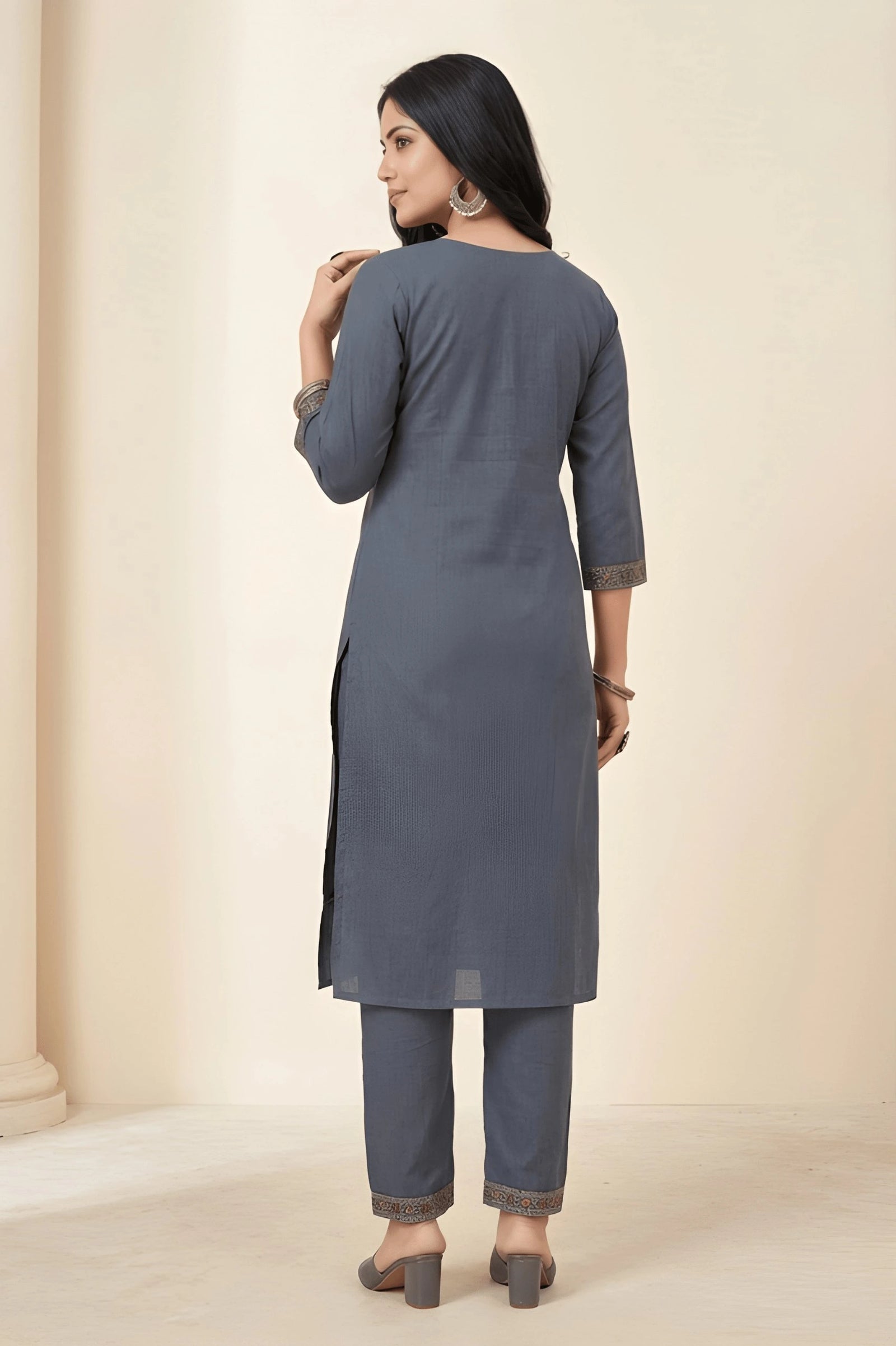 Woman wearing a gray kurta with pants against a beige background