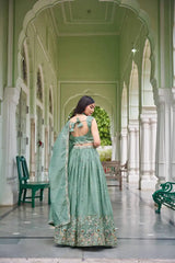Back view of green thread embroidered lehenga showing fancy bow-tie back choli and dupatta drape