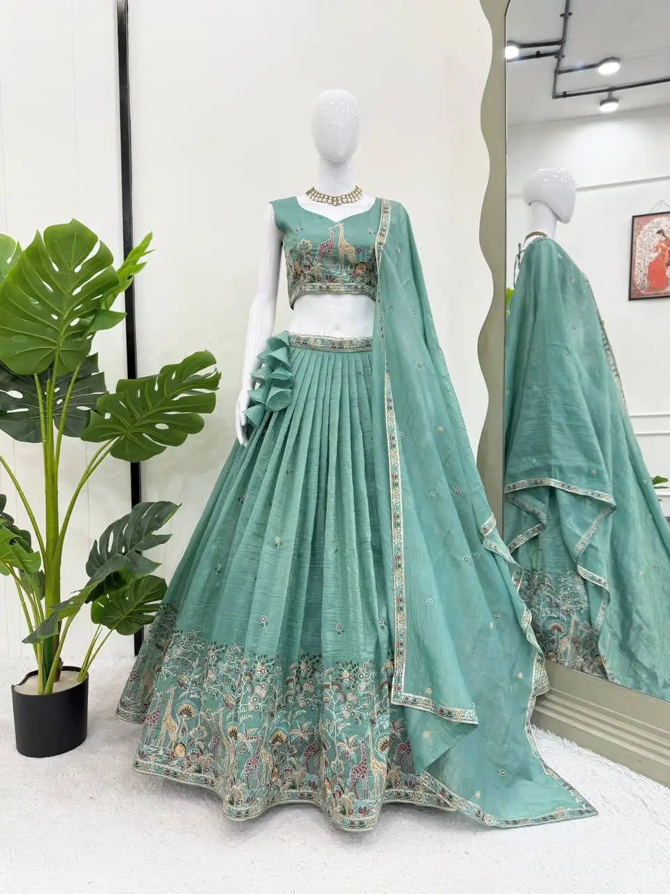 Mannequin display of full green gold crush lehenga set with choli, dupatta and Mughal hem border