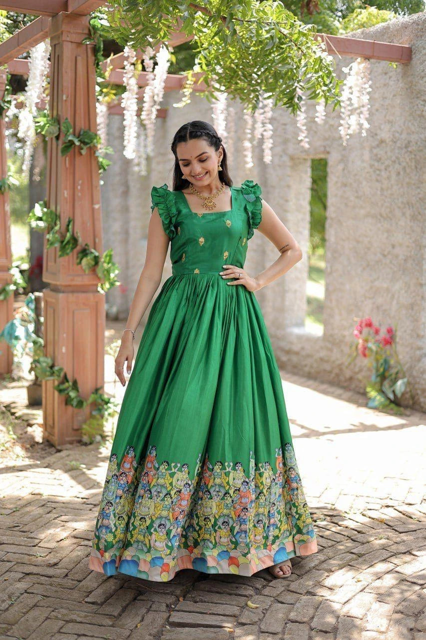 Woman in a green dress with floral patterns standing outdoors.