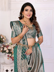 Woman in a traditional saree with jewelry against a white wall