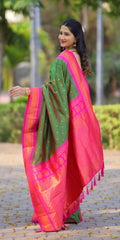 Woman wearing a pink and green saree with a blurred outdoor background