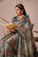 Woman in a floral saree holding a book against a neutral background