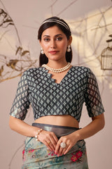 Woman wearing a traditional outfit with a patterned blouse and floral skirt against a neutral background