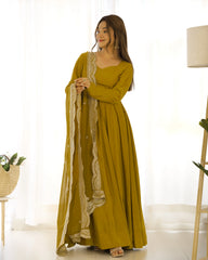 Woman wearing a mustard yellow dress with lace details in a bright room.