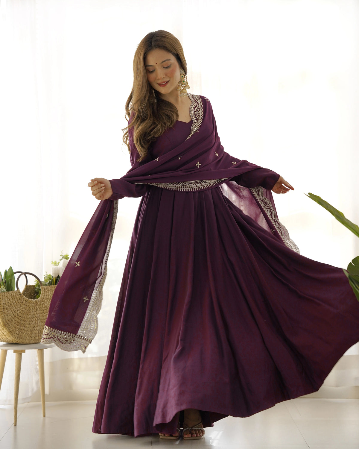 Woman wearing a long purple dress with a matching shawl indoors.