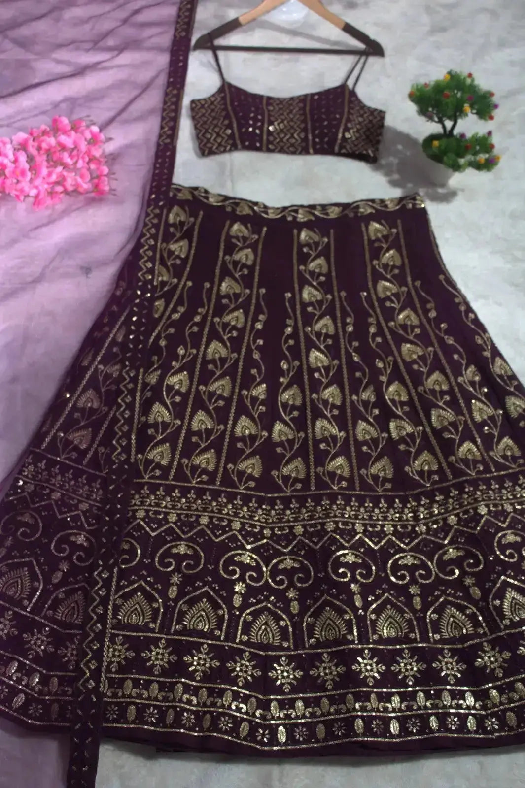 Wine Sequins Embroidered Lehenga hanging display – full lehenga skirt showing gold thread motifs and border detail