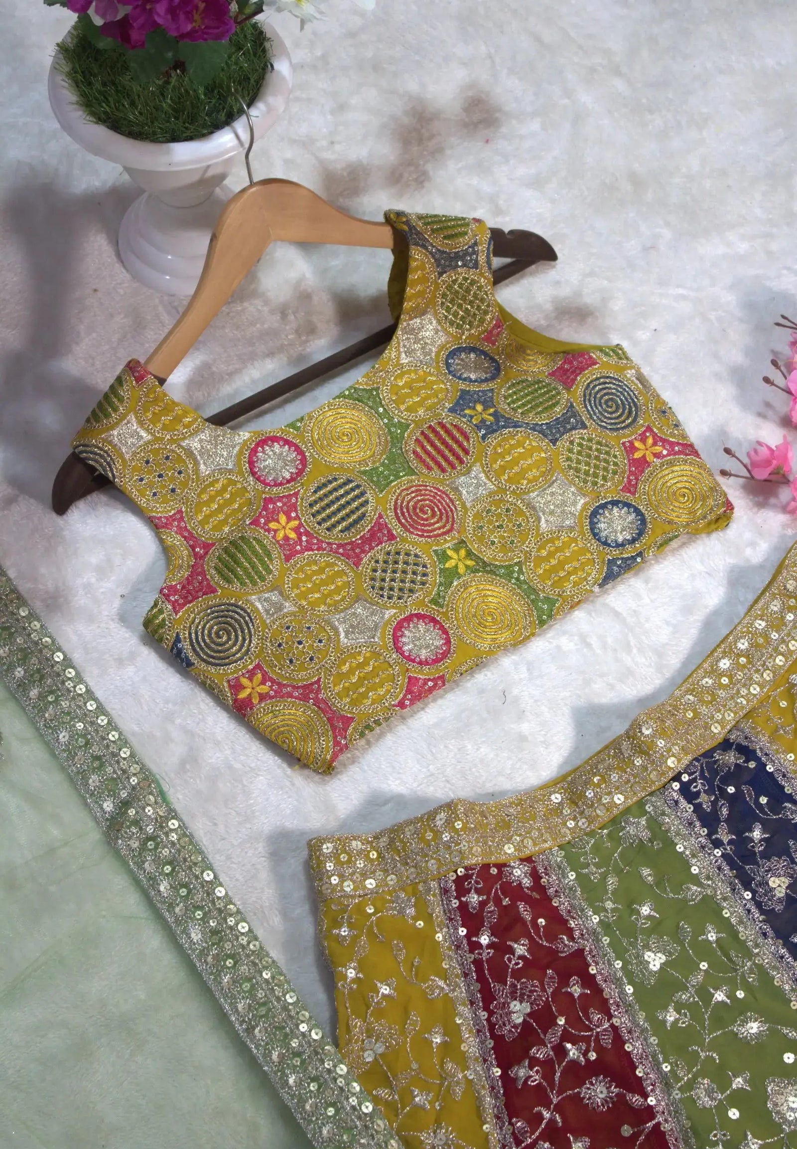 Multicolor embroidered choli flat lay on hanger – circular zardosi work in multicolor thread and sequins