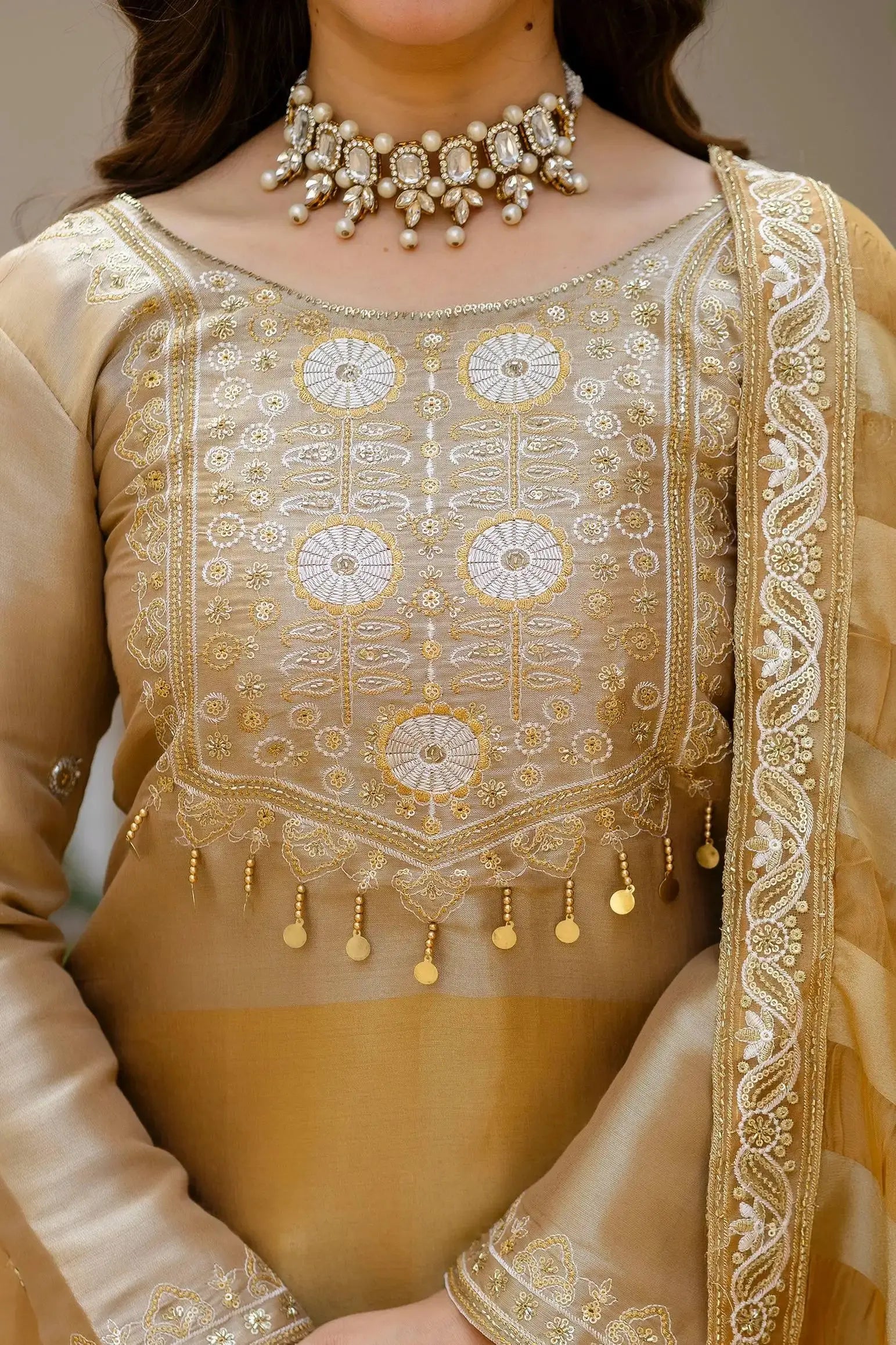 Beige Embroidered Lehenga yoke close-up – circular floral handwork embroidery in gold and white thread with coin tassels