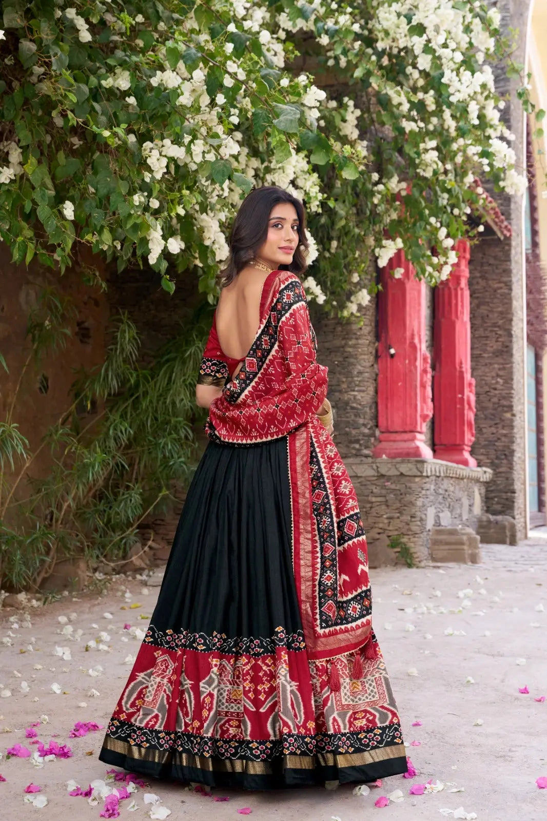 Black Floral Print Lehenga back view – open back choli, patola elephant border skirt with gold zari hem, foil work detail