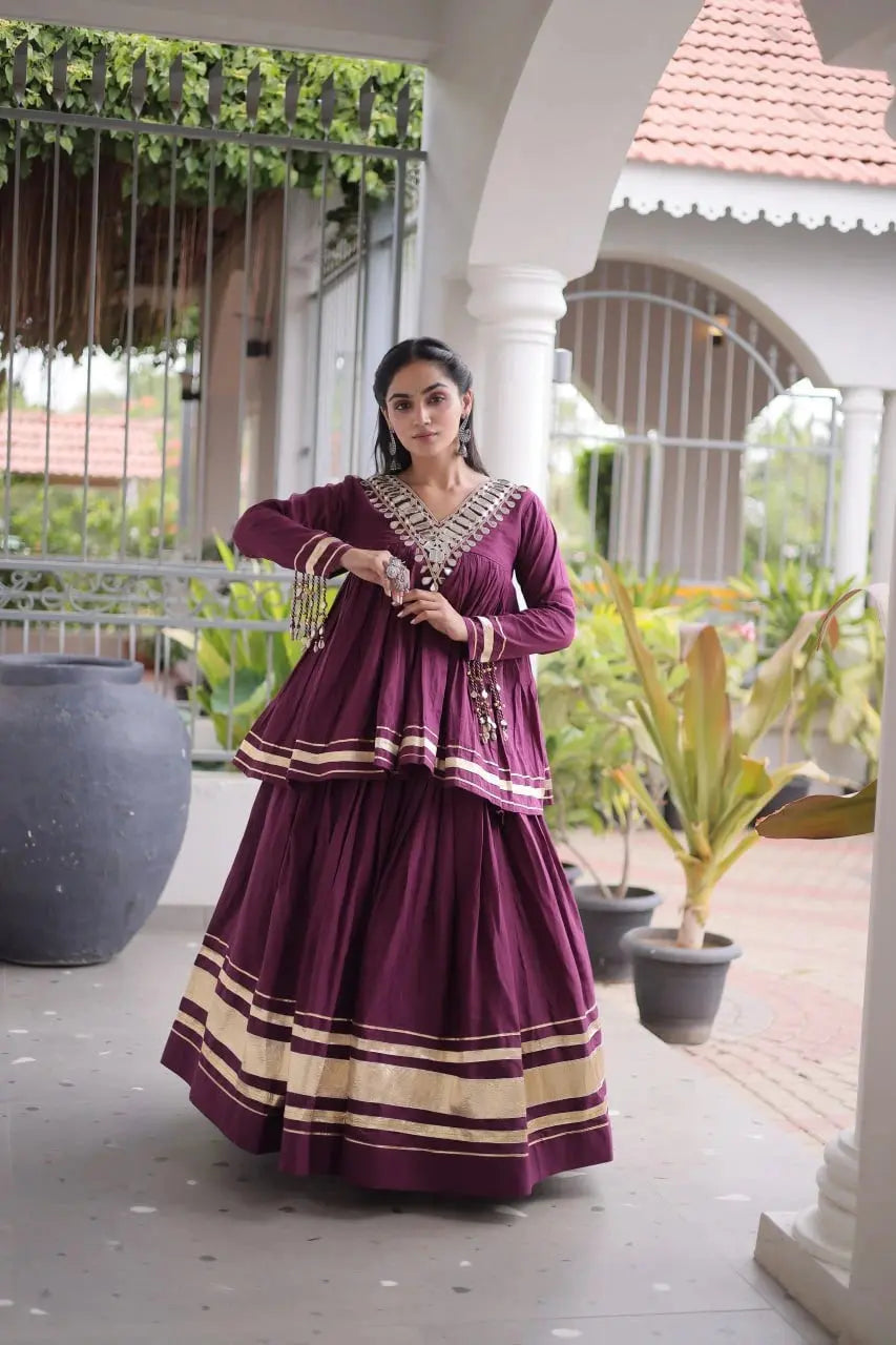 Purple Zari Work Lehenga – Model wearing purple peplum lehenga set with gold zari borders and kodi tassel cuffs