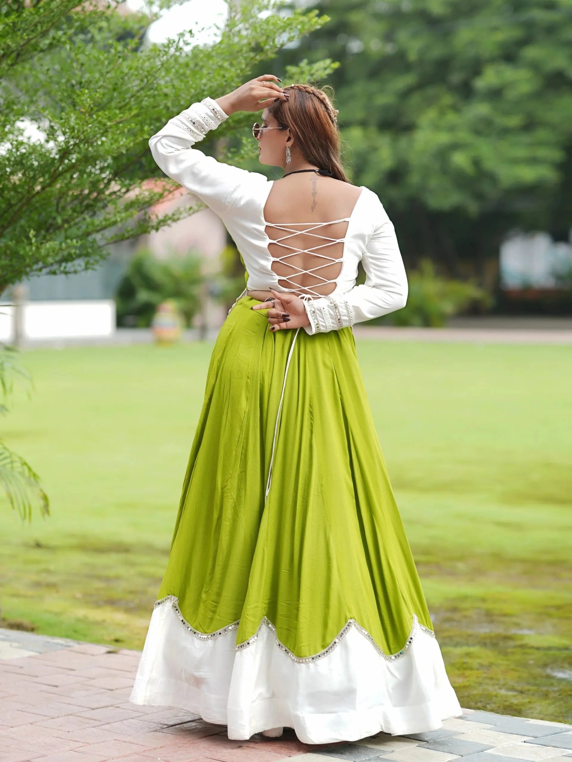 Green Mirror Lace Work Lehenga – Choli close-up showing mirror-sequin trim, chevron peplum overlay with cowrie shell fringe