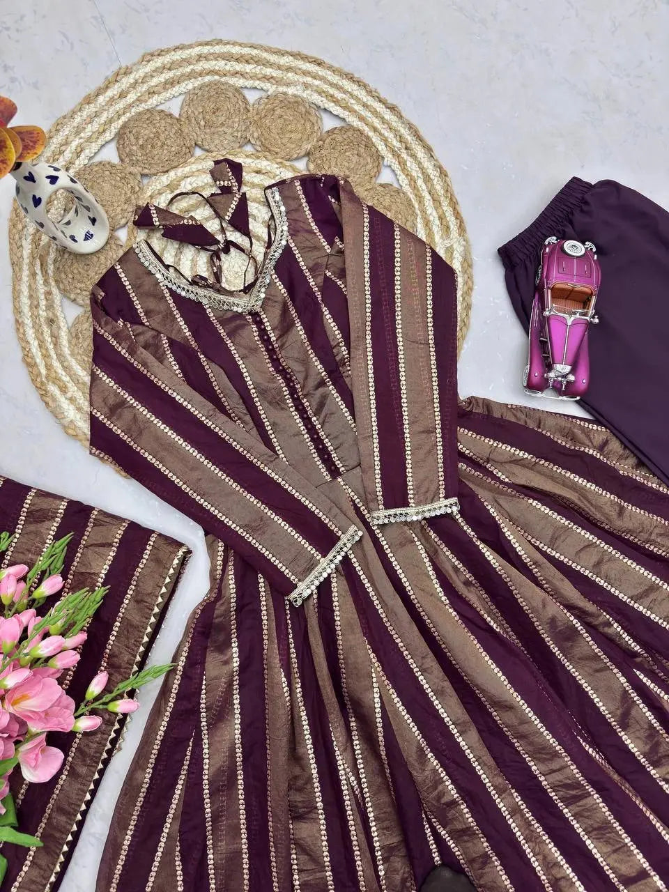 Close-up flat lay of mirror work neckline and cuff detail on wine suit
