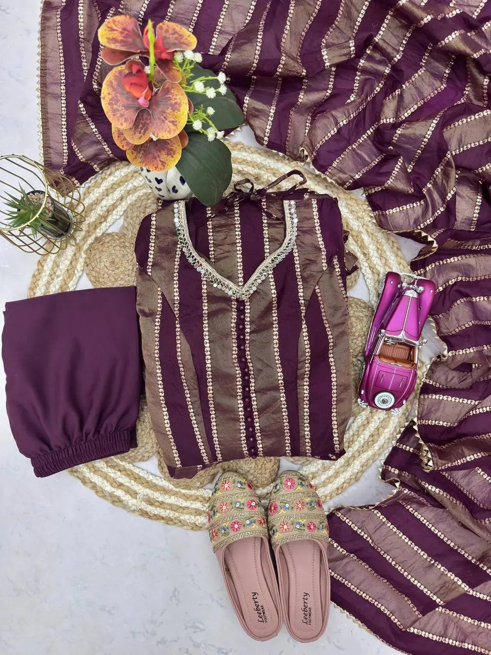 Full flat lay of wine mirror work suit set with dupatta, pants and footwear