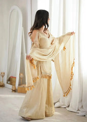 KU212 Beige Mirror Work Suit – Side/three-quarter view with dupatta flowing toward window, showing cold shoulder bell sleeve and Palazzo width