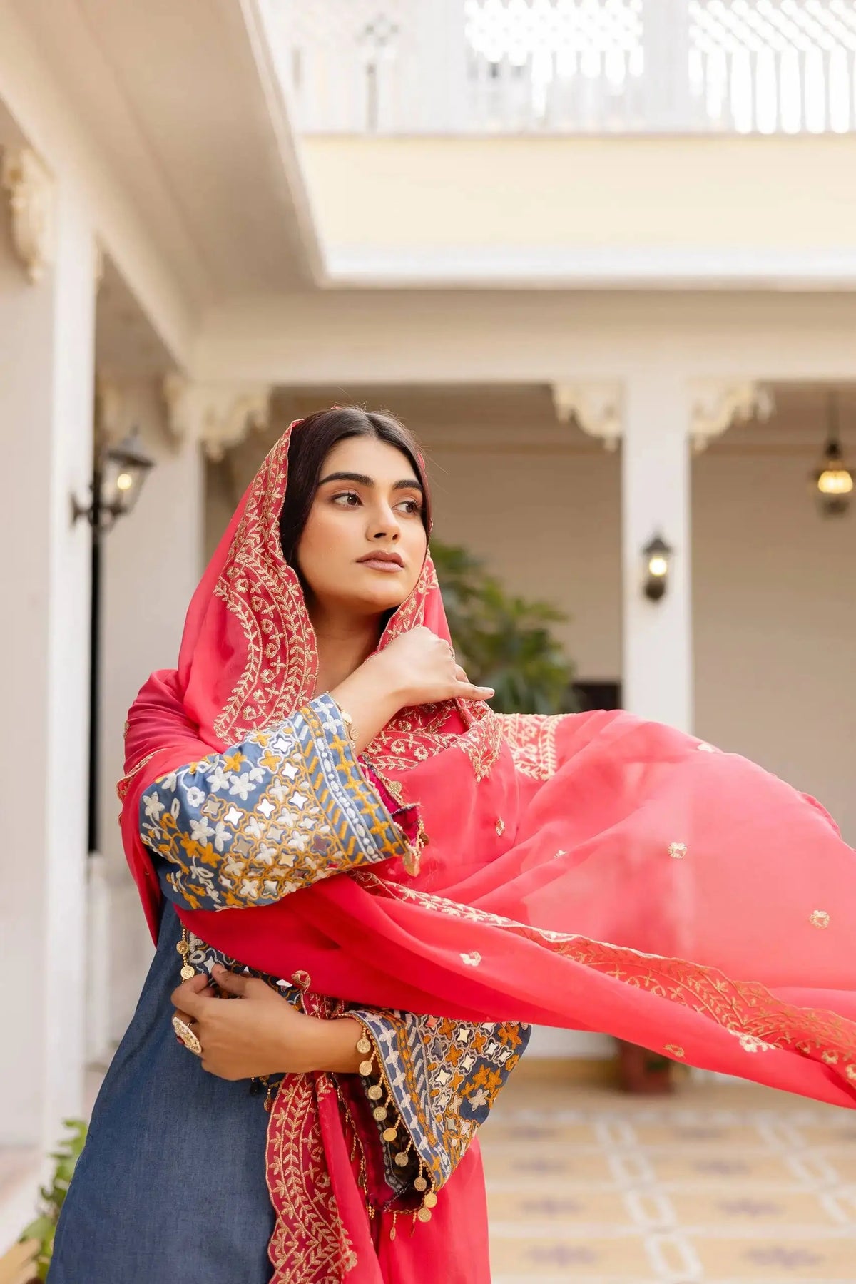 Grayish Blue Heavy Embroidered Suit KU216 – Dupatta draped over head in traditional style, coral-pink with gold Zari border
