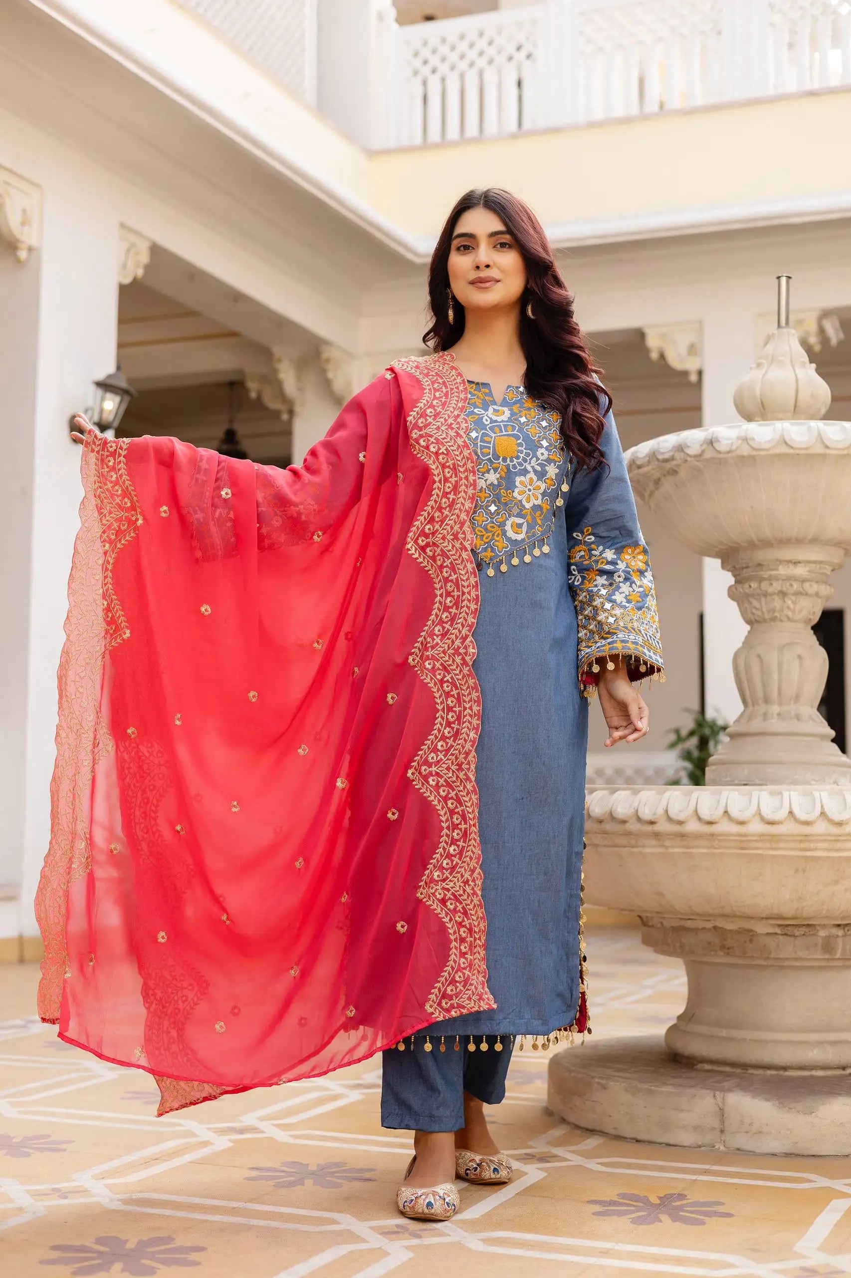 Grayish Blue Heavy Embroidered Suit KU216 – Model holding coral-pink dupatta open wide, showing full embroidery and tassel detail