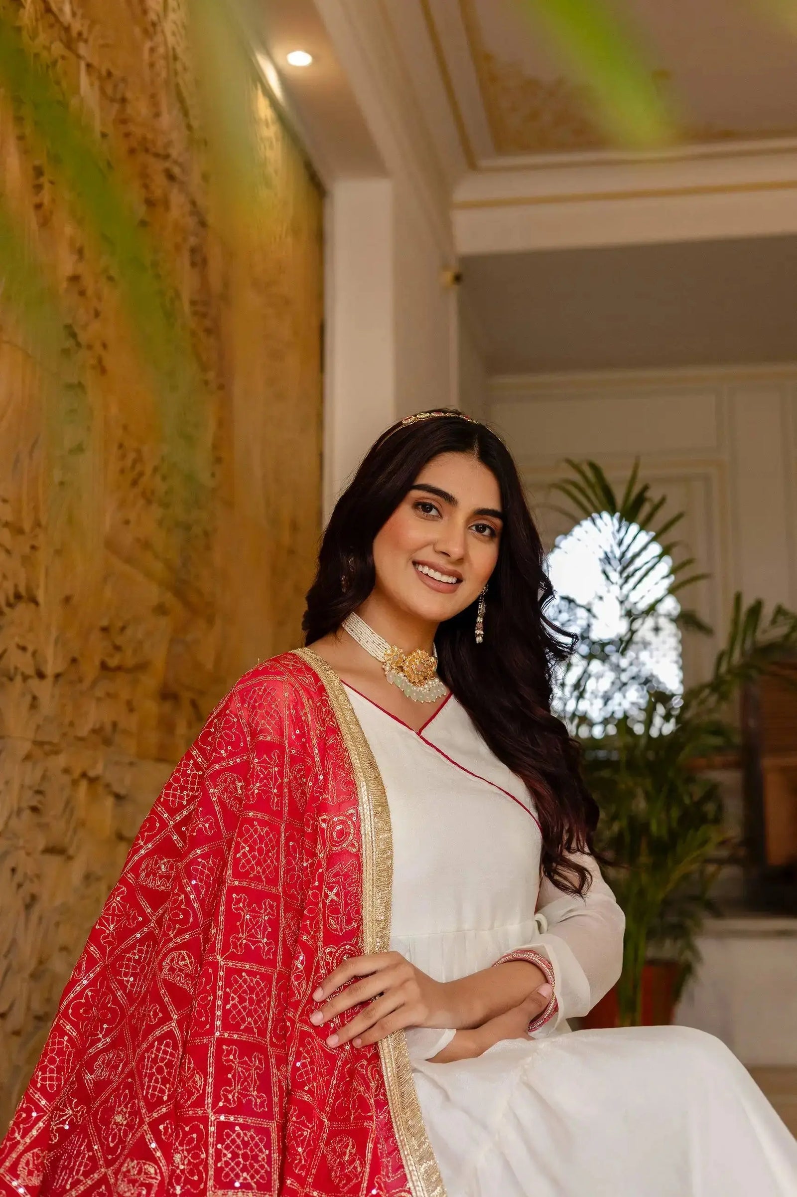 KU217 White Heavy Embroidered Anarkali Suit – Seated portrait with dark pink Bandhej dupatta