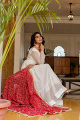 KU217 White Anarkali Suit – Seated model with dark pink dupatta spread, gold zari border visible