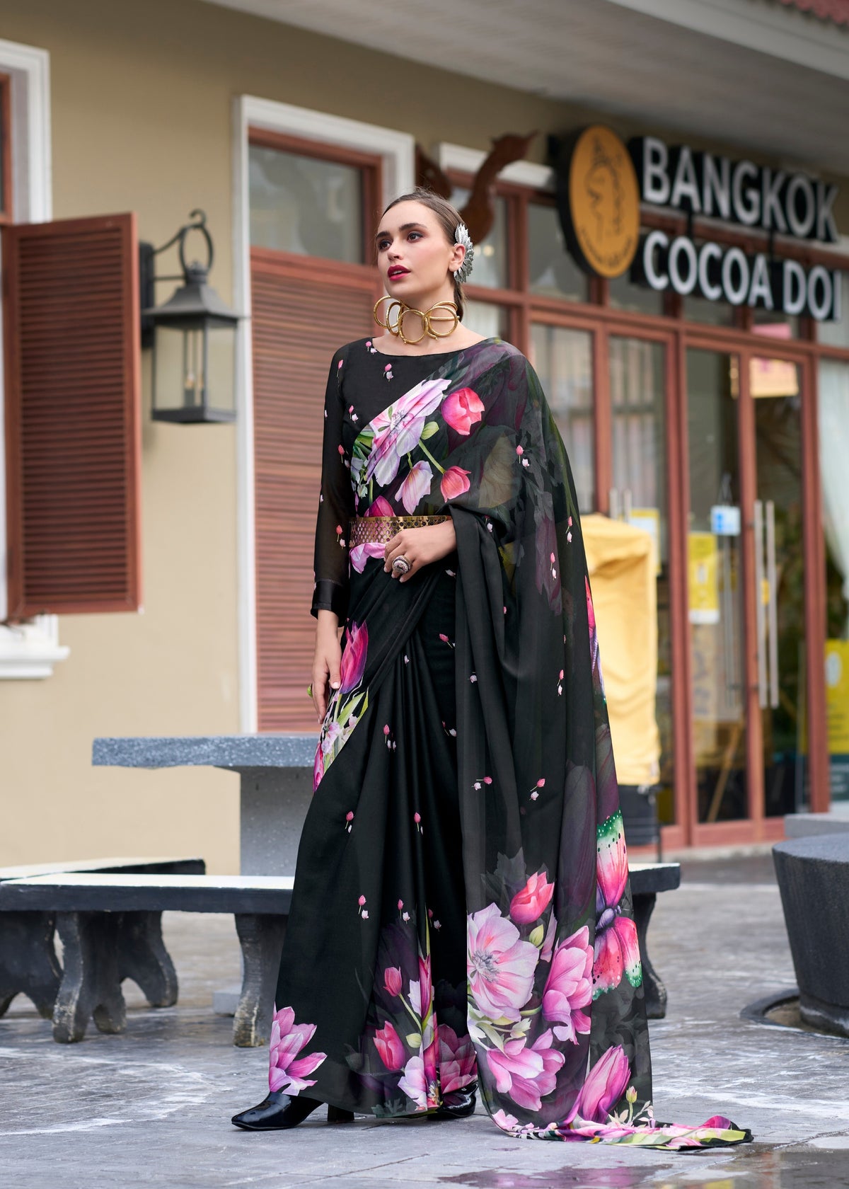 Woman in a floral dress standing in front of a building with 'Bangkok Cocoa' sign.