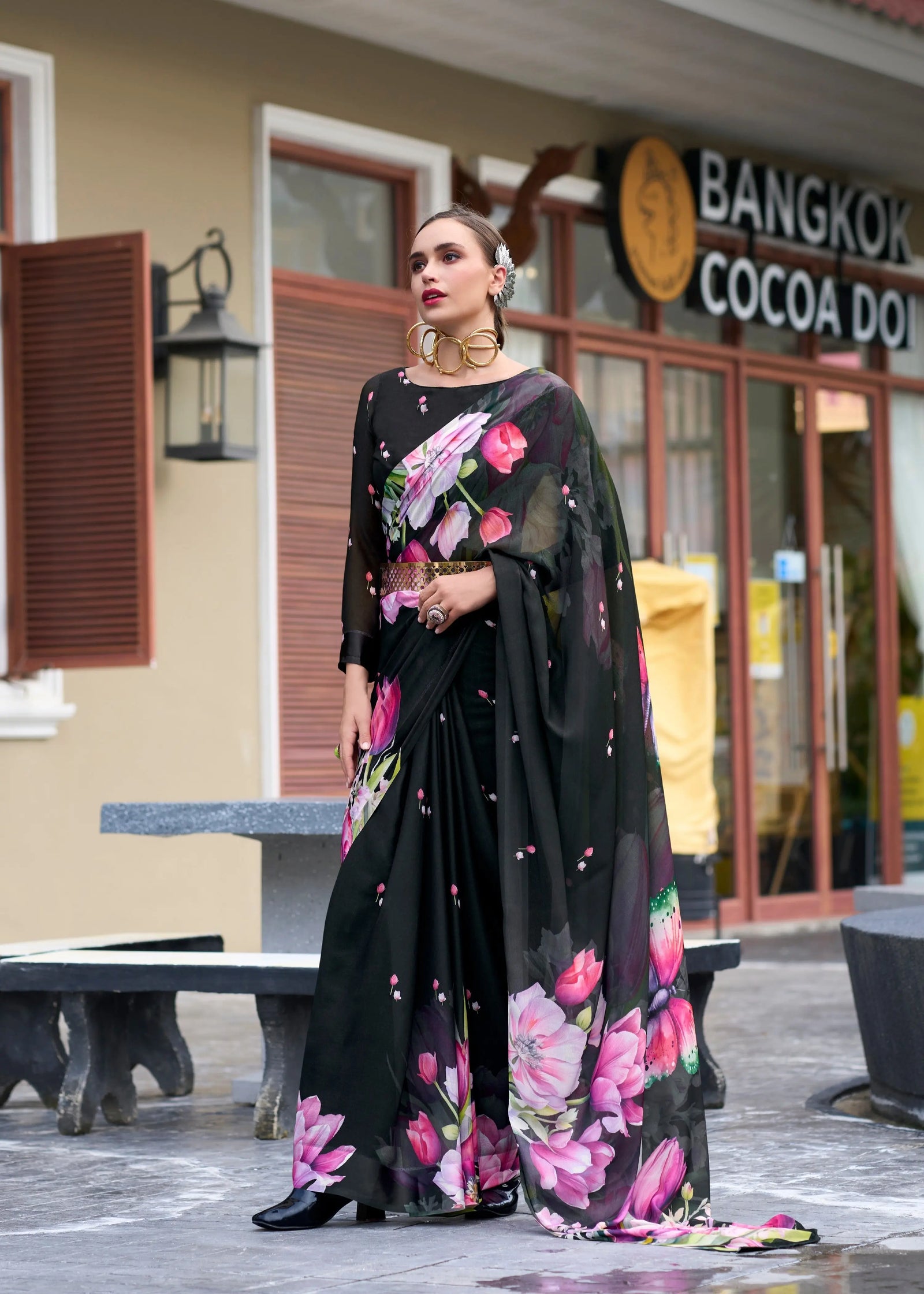 Woman in a floral dress standing in front of a building with 'Bangkok Cocoa' sign.